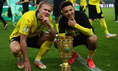 Dortmund's Norwegian forward Erling Braut Haaland (L) and Dortmund's English midfielder Jadon Sancho pose with the trophy after winning the German Cup (DFB Pokal) final
