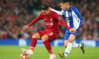 LIVERPOOL, ENGLAND - APRIL 09: Roberto Firmino of Liverpool holds off a challenge from Otavio of Porto during the UEFA Champions League Quarter Final first leg match between Liverpool and Porto at Anfield on April 09, 2019 in Liverpool, England.