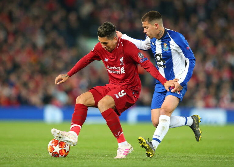 LIVERPOOL, ENGLAND - APRIL 09: Roberto Firmino of Liverpool holds off a challenge from Otavio of Porto during the UEFA Champions League Quarter Final first leg match between Liverpool and Porto at Anfield on April 09, 2019 in Liverpool, England.
