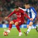 LIVERPOOL, ENGLAND - APRIL 09: Roberto Firmino of Liverpool holds off a challenge from Otavio of Porto during the UEFA Champions League Quarter Final first leg match between Liverpool and Porto at Anfield on April 09, 2019 in Liverpool, England.