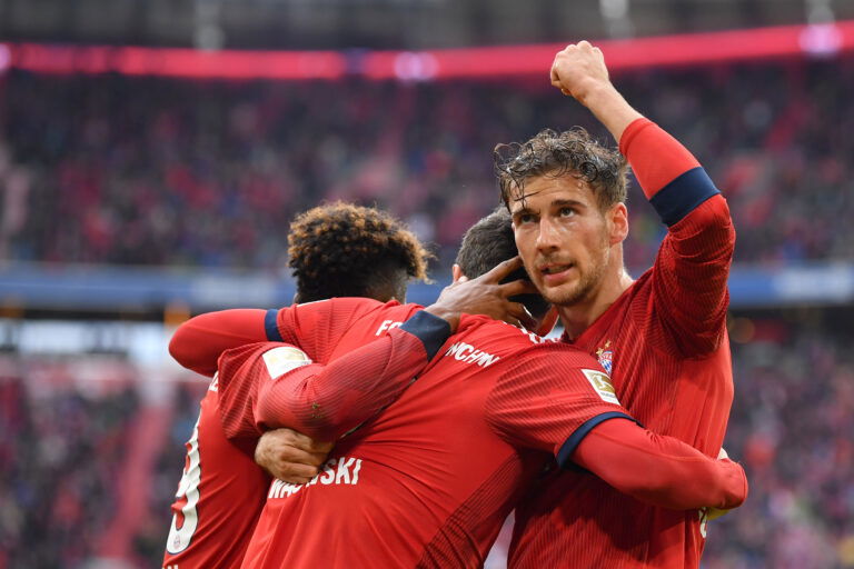 MUNICH, GERMANY - MAY 04: Robert Lewandowski of Bayern Munich celebrates with teammates Kingsley Coman (l) and Leon Goretzka after scoring his team's first goal during the Bundesliga match between FC Bayern Muenchen and Hannover 96 at Allianz Arena on May 04, 2019 in Munich, Germany.
