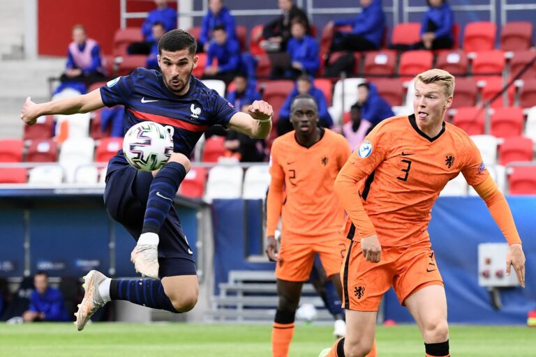 France's midfielder Houssem Aouar (L) kicks the ball next to Netherlands' defender Perr Schuurs during the UEFA Under21 Championship quarter-final football match Netherlands v France in Budapest, on May 31, 2021.