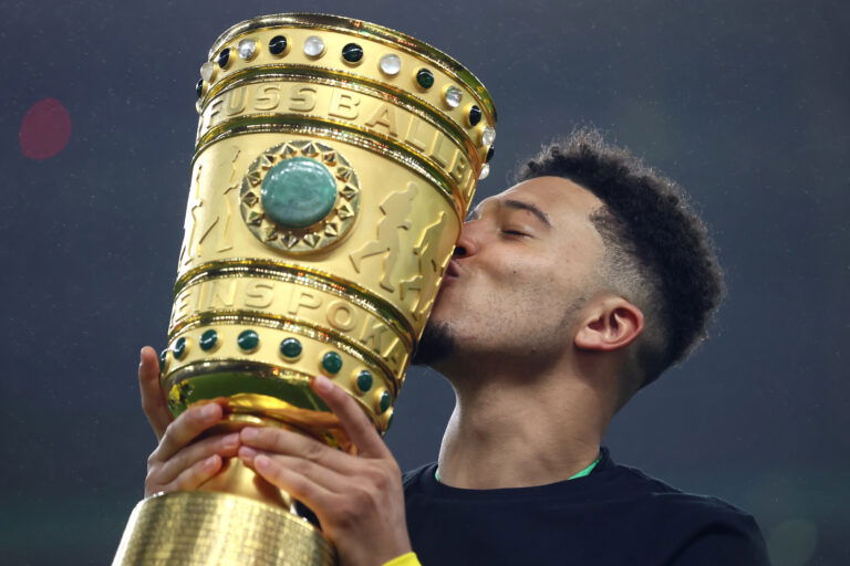 BERLIN, GERMANY - MAY 13: Jadon Sancho of Dortmund kisses the trophy after winning the DFB Cup final match between RB Leipzig and Borussia Dortmund at Olympic Stadium on May 13, 2021 in Berlin, Germany.
