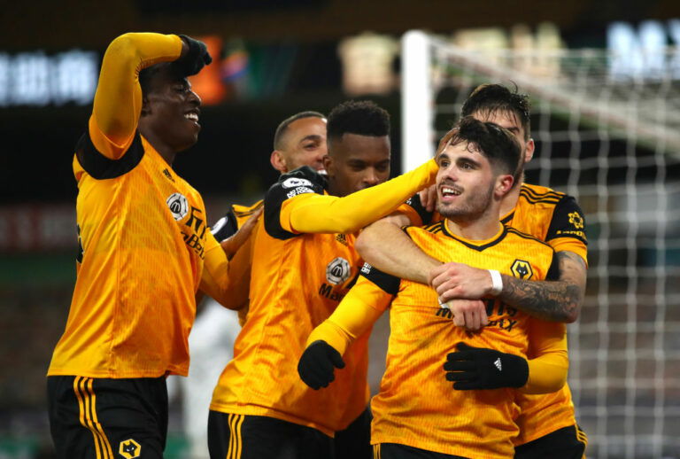 WOLVERHAMPTON, ENGLAND - DECEMBER 15: Pedro Neto of Wolves celebrates with teammates Nelson Semedo and Ruben Neves and Marcal after scoring their sides second goal during the Premier League match between Wolverhampton Wanderers and Chelsea at Molineux on December 15, 2020 in Wolverhampton, England. The match will be played without fans, behind closed doors as a Covid-19 precaution. (Photo by Michael Steele/Getty Images)