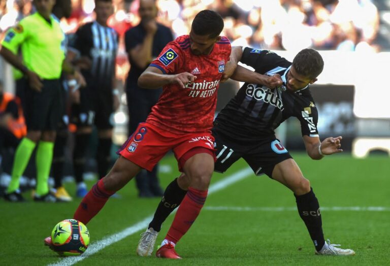 Lyon's French midfielder Houssem Aouar (L) fights for the ball with Anger's French midfielder Jimmy Cabot (R) during the French L1 football match between Angers SCO and Olympique Lyonnais (Lyon) at The Raymond Kopa Stadium in Angers, western France on August 15, 2021. (Photo by JEAN-FRANCOIS MONIER / AFP) (Photo by JEAN-FRANCOIS MONIER/AFP via Getty Images)